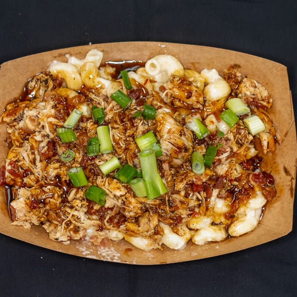 Jackpot's BBQ pulled chicken mac and cheese with green onions in a brown paper tray.